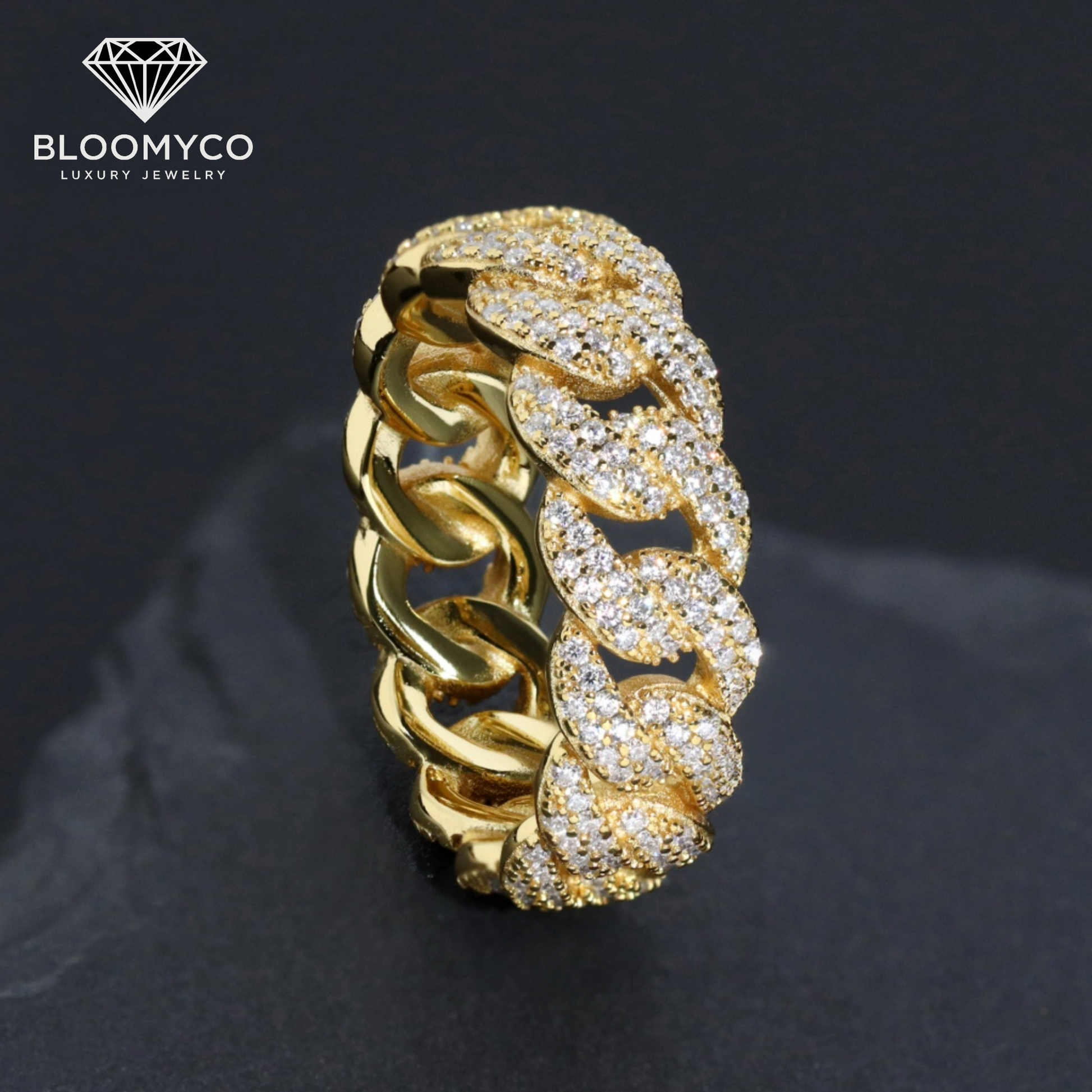 Gold chain ring with diamonds on a dark background, featuring the Bloomyco brand.