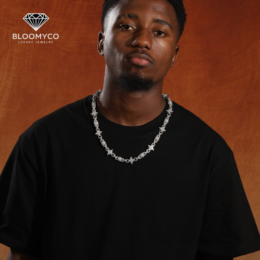 Silver chain necklace with star designs worn by a person, branded as BloomyCo. BloomyCo Star Link Chain iced out with VVS moissanite stones in 925 silver